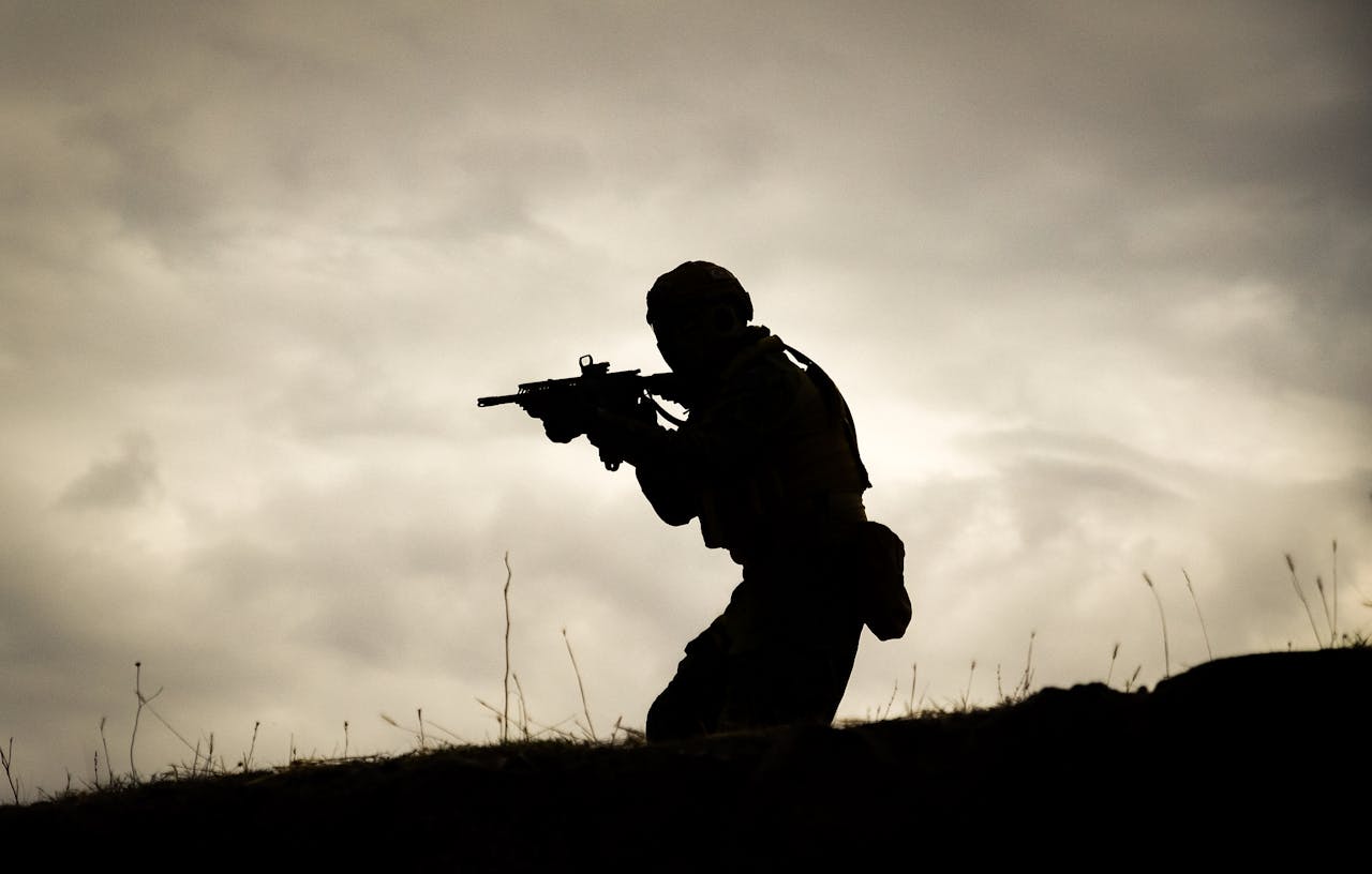 A Man in Black Jacket Holding a Rifle
